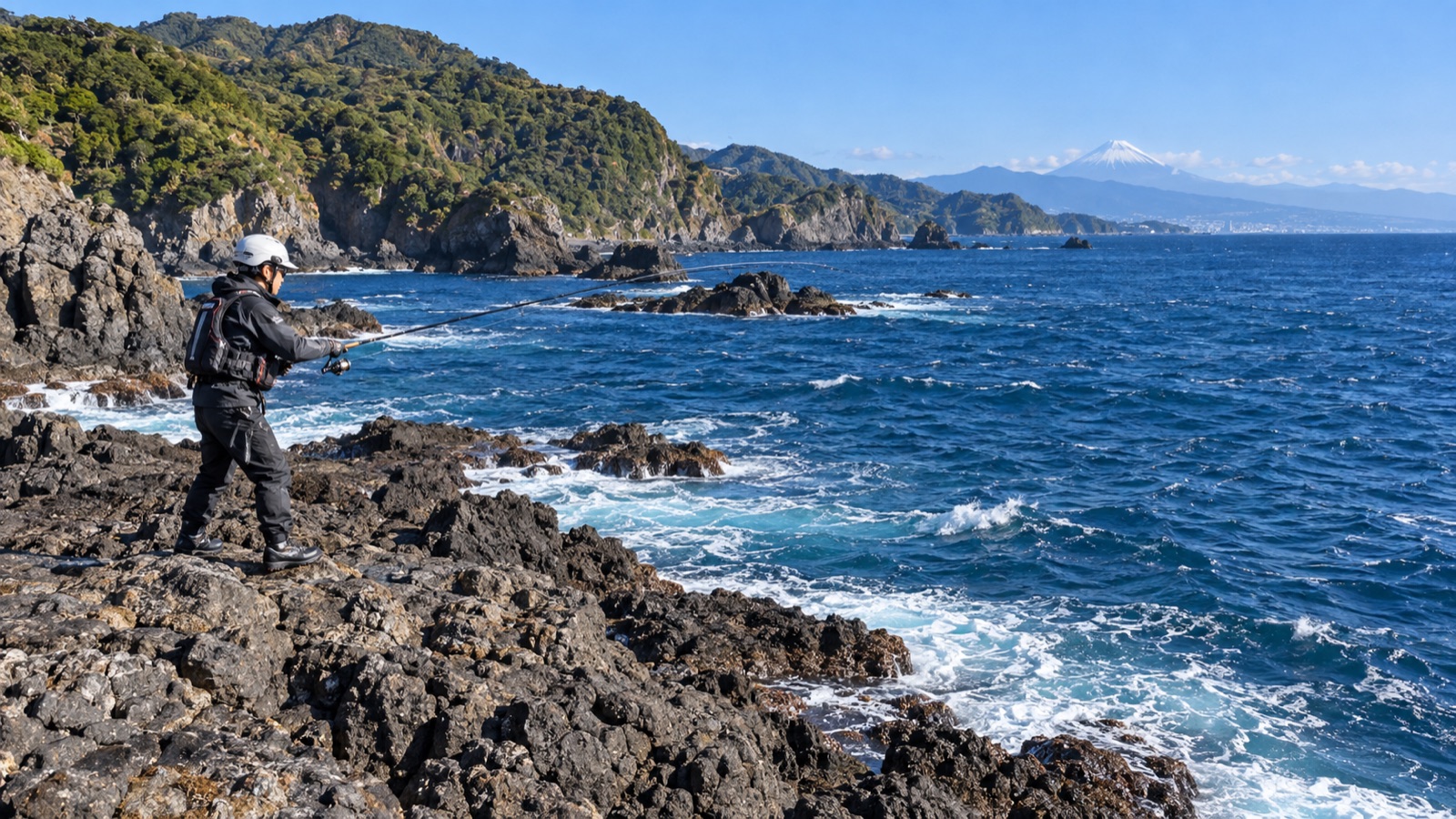 関東の太平洋側の荒々しい地磯と青い海でキャストするアングラー